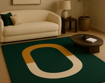 May include: A modern living room featuring a dark green rug with an abstract design in gold and white. The rug is the focal point, complemented by a cream-colored sofa, a wooden coffee table, and a potted plant.