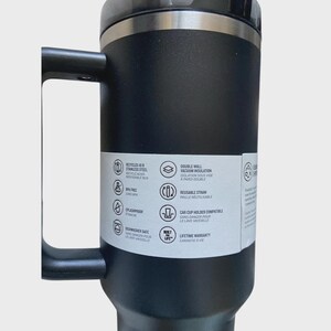 May include: Black stainless steel travel mug with a handle. Features include double-wall vacuum insulation, a reusable straw, and car cup holder compatibility. The mug is dishwasher safe and has a lifetime warranty.