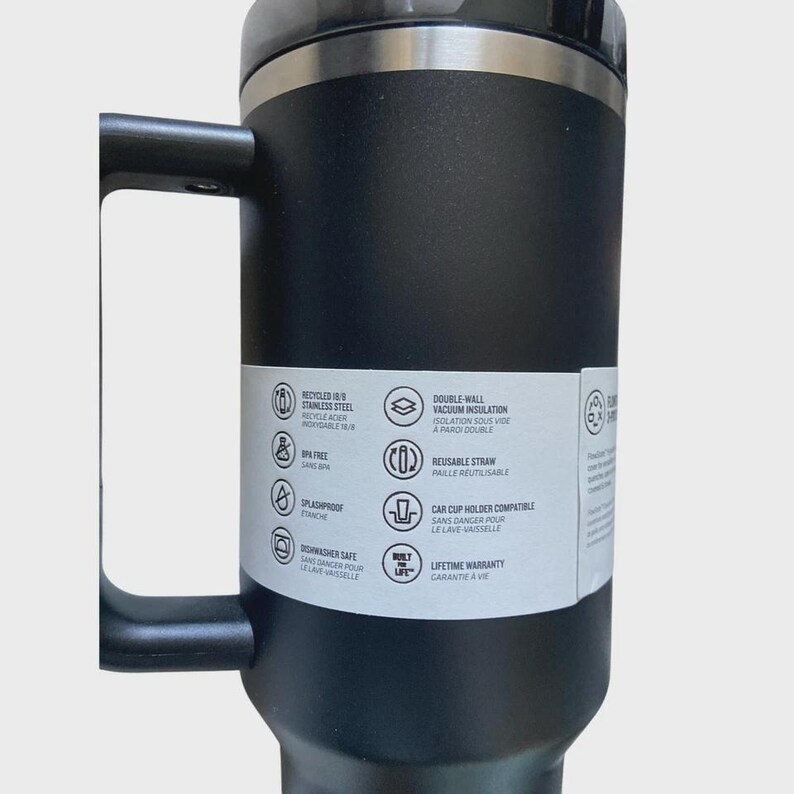 May include: Black stainless steel travel mug with a handle. Features include double-wall vacuum insulation, a reusable straw, and car cup holder compatibility. The mug is dishwasher safe and has a lifetime warranty.