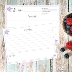 May include: Two white recipe cards with purple borders and lavender floral accents. The top card features fields for Recipe, Prep Time, Cooking Time, Servings, and Ingredients. The bottom card includes an Instructions section and a My Notes box.