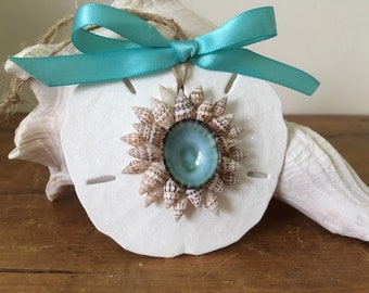 Zanddollarornament met waterblauwe strandbloem en suikerglitter