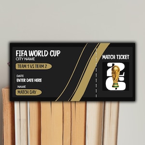 May include: A black and gold FIFA World Cup match ticket. The ticket includes the text "FIFA WORLD CUP", "TEAM 1 VS TEAM 2", "ENTER DATE HERE", and "MATCH DAY". A gold trophy image is on the right side of the ticket.