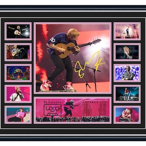 May include: Framed collage with multiple images of a musician playing a guitar on stage. The central image is larger, surrounded by smaller photos. A pink banner with text and a signature is also included.