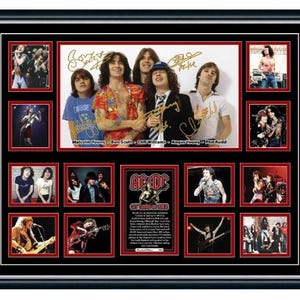 May include: Framed AC/DC band collage with multiple photos of the band members. The central image shows the band with signatures. The frame is black with red borders around each photo. The text includes the names of the band members.