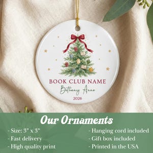 May include: A round white ceramic ornament featuring a green Christmas tree decorated with small books and a red bow at the top. The text reads BOOK CLUB NAME, Bethany Anne, and 2026. A gold hanging cord is attached to the top of the 3 inch by 3 inch ornament.