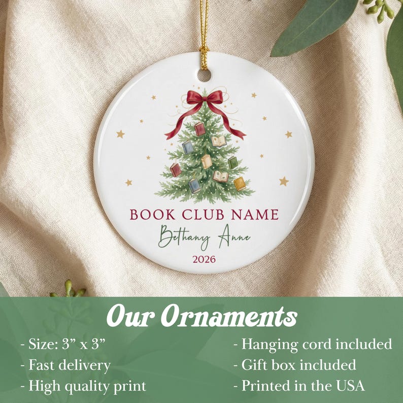 May include: A round white ceramic ornament featuring a green Christmas tree decorated with small books and a red bow at the top. The text reads BOOK CLUB NAME, Bethany Anne, and 2026. A gold hanging cord is attached to the top of the 3 inch by 3 inch ornament.