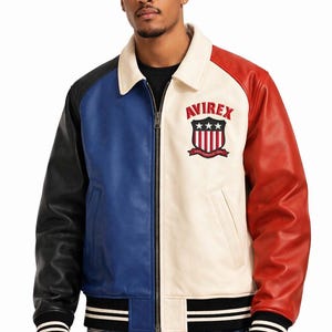 Pu&ograve; includere: Una giacca in pelle color-block con manica destra nera, pannello pettorale destro blu e pannello pettorale sinistro color crema con manica sinistra rossa. La giacca presenta un colletto color crema, una cerniera frontale e il logo AVIREX.