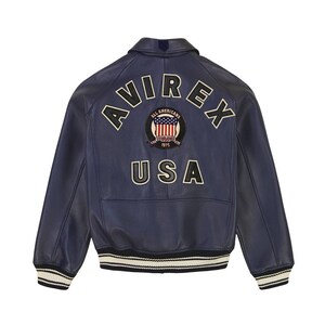 May include: A navy blue leather varsity jacket featuring the text AVIREX and USA in cream-colored lettering on the back. A circular patch in the center displays an American flag graphic with the text ALL AMERICANS ESTABLISHED 1975. The jacket has striped ribbed cuffs and hem.