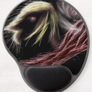 Peut inclure: Tapis de souris ergonomique avec repose-poignet noir. Le tapis présente un motif d'art numérique d'une créature avec un œil rouge, une fourrure jaune et blanche et des vrilles rouges sur fond noir. Le design est abstrait et artistique.