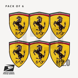 Può includere: Sei toppe Ferrari gialle e nere con l'iconico logo del cavallino rampante. Ogni toppa ha la forma di uno scudo con un bordo rosso e verde. Il testo "SF" si trova nella parte inferiore di ogni toppa. Il testo "PACK OF 6" è in alto.