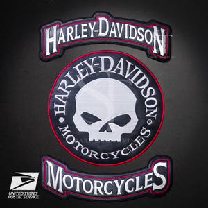 Könnte beinhalten: Drei Harley-Davidson Motorrad-Patches. Der obere Patch zeigt "HARLEY-DAVIDSON" in weißer Schrift auf schwarzem Hintergrund mit rotem Rand. Der mittlere Patch zeigt einen Totenkopf und die Worte "HARLEY-DAVIDSON MOTORCYCLES". Der untere Patch lautet "MOTORCYCLES".