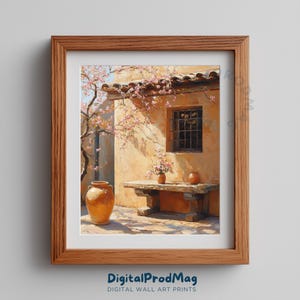 Könnte beinhalten: Ein gerahmter Druck einer sonnigen Hofszene. Das Kunstwerk zeigt ein rustikales Gebäude mit einem Fenster, einer Holzbank und Terrakottatöpfen. Rosa Blüten und ein blauer Himmel verleihen der Szene Farbe.