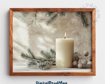 May include: A framed print featuring a lit, ivory-colored pillar candle. The candle is surrounded by frosted evergreen branches and berries. The background is a neutral, textured surface. The frame is made of wood. The text "DigitalProdMag" is at the bottom.
