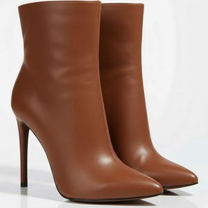 May include: A pair of brown leather ankle boots with pointed toes and stiletto heels. The boots have a smooth, polished finish and a sleek, modern design. The heels are approximately 4 inches high.