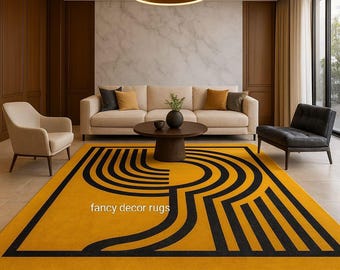 Op de afbeelding: Een rechthoekig vloerkleed met een opvallende mosterdgele achtergrond en een zwart geometrisch patroon van gebogen en rechte lijnen. De tekst "fancy decor rugs" is in het wit op het oppervlak van het kleed gedrukt.