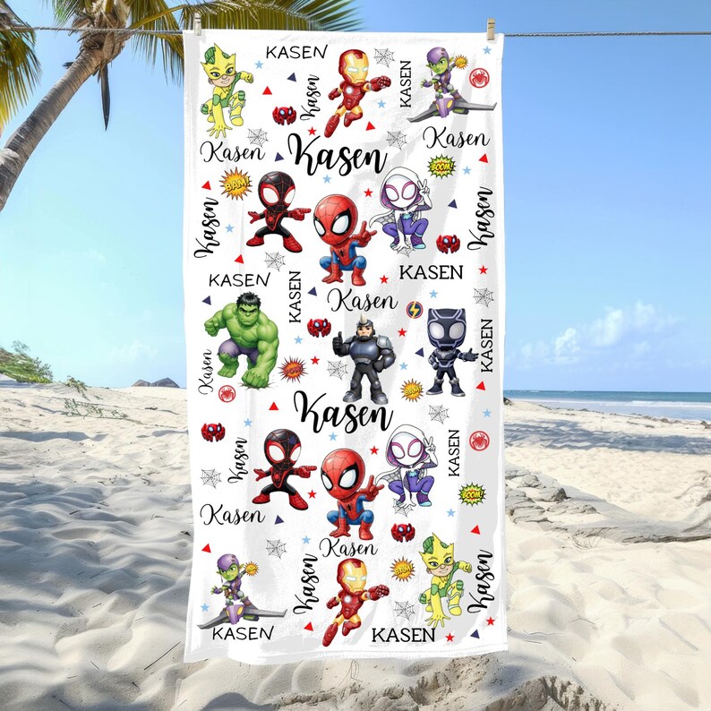 Pu&ograve; includere: Telo mare bianco con illustrazioni colorate di vari supereroi. Il telo ha il nome "Kasen" stampato pi&ugrave; volte in un carattere stilizzato, insieme ad altri elementi grafici. L'asciugamano &egrave; appeso a un filo per stendere i panni sulla spiaggia.