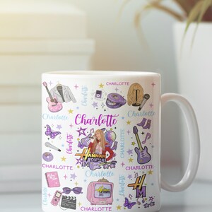 K&ouml;nnte beinhalten: Wei&szlig;e Keramiktasse mit einem farbenfrohen Design mit dem Namen "Charlotte" und verschiedenen Illustrationen. Das Design umfasst eine Gitarre, ein Mikrofon, Schmetterlinge und einen Fernseher. Die Tasse hat einen wei&szlig;en Griff.