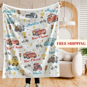 Puede incluir: Manta blanca con dibujos de coches de dibujos animados, rayos, estrellas y los textos "Hollis" y "Ka-Chow". El dise&ntilde;o incluye banderas de carreras, trofeos y sem&aacute;foros. Una manta decorativa para los amantes de los coches.