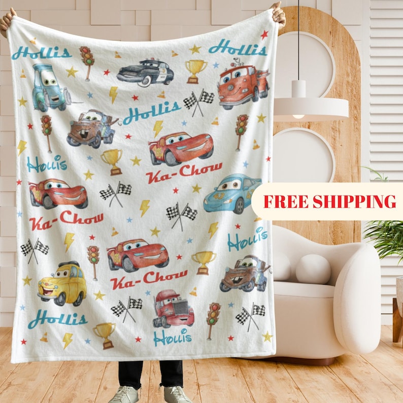 Puede incluir: Manta blanca con dibujos de coches de dibujos animados, rayos, estrellas y los textos "Hollis" y "Ka-Chow". El dise&ntilde;o incluye banderas de carreras, trofeos y sem&aacute;foros. Una manta decorativa para los amantes de los coches.