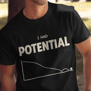 Pode incluir: Camiseta preta com o texto branco "I HAD POTENTIAL" acima de um gráfico de linha branco com um ponto azul. A camiseta tem gola redonda e parece ser de algodão.