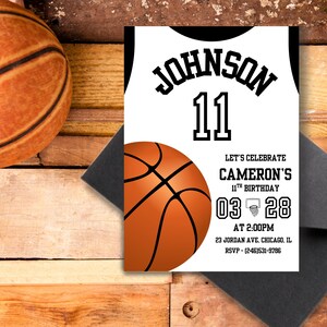 May include: A basketball-themed birthday invitation. The design features a jersey with the name "JOHNSON" and the number "11". The invitation includes the date, time, and location of the party. A basketball and envelope are also visible.