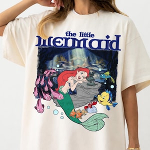 Pu&ograve; includere: Una tazza di ceramica bianca con manico nero e la scritta "But First, Coffee" in grassetto nero. La tazza &egrave; appoggiata su una superficie di legno. La tazza &egrave; alta circa 10 cm.