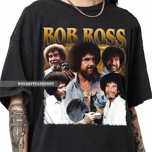 Puede incluir: Camiseta negra con texto dorado "BOB ROSS" y un collage de imágenes de Bob Ross. El diseño incluye múltiples retratos de Bob Ross, con una pintura de paisaje en el fondo. La camiseta tiene cuello redondo.