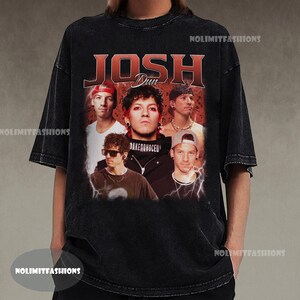 May include: Black vintage-style t-shirt featuring a graphic of the band members with the name "JOSH DUN" in red. The shirt has a distressed look and a crew neck.