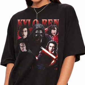 May include: Black t-shirt featuring a graphic of Kylo Ren from Star Wars. The design includes multiple images of the character, with the name "KYLO REN" in red text across the top. The shirt is a crew neck style.