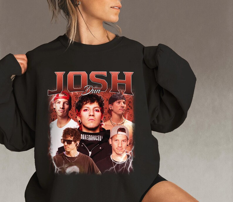 May include: Black crew neck sweatshirt featuring a vintage-style graphic of Josh Dun with the text "JOSH DUN" in red. The graphic includes multiple images of the artist. The sweatshirt is a dark color.