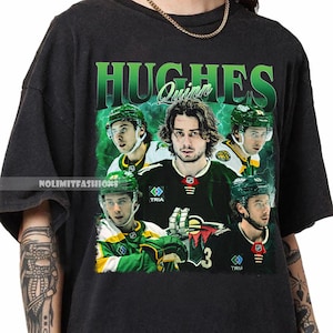 以下が含まれることがあります： 黒いTシャツ。緑と白のユニフォームを着たホッケー選手のコラージュ。選手の画像の上に緑色で「HUGHES」という名前がプリントされ、その下に「Quinn」という名前がプリントされています。シャツの側面には「NOLIMITFASHIONS」という文字がプリントされています。