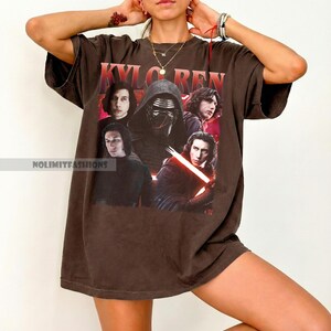 May include: Brown oversized t-shirt featuring a graphic of Kylo Ren from Star Wars. The design includes multiple images of the character and the text "KYLO REN" in red. The shirt has short sleeves and a relaxed fit.
