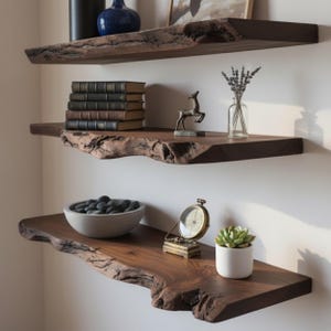 May include: Three dark wood floating shelves with live edges are mounted on a white wall. The shelves hold decorative items, including books, a small deer statue, a bowl of stones, a potted succulent, and a vintage compass.