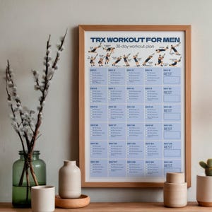 May include: A framed 30-day TRX workout plan poster with blue text and a grid layout. The top section features illustrations of individuals performing various exercises. The text reads TRX WORKOUT FOR MEN 30-day workout plan, followed by a daily schedule.