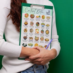 K&ouml;nnte beinhalten: Ein gr&uuml;nes Klemmbrett mit einer gedruckten Liste von 30 Mittagsideen f&uuml;r eine Cortisol-Detox-Di&auml;t. Die Liste enth&auml;lt verschiedene farbenfrohe Lebensmittelillustrationen und die Worte "Cortisol Detox" oben.