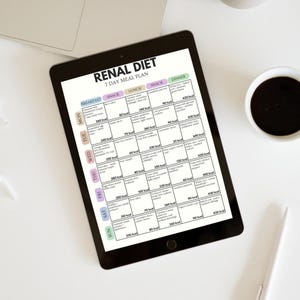 Puede incluir: Una tableta negra muestra un "RENAL DIET 7 DAY MEAL PLAN" con sugerencias de comidas diarias. El plan incluye opciones para desayuno, merienda, almuerzo, merienda y cena. Una taza de caf&eacute; y un bol&iacute;grafo est&aacute;n sobre la superficie blanca.