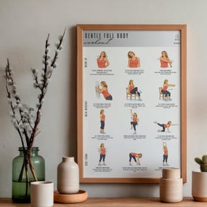Puede incluir: Un p&oacute;ster enmarcado "Gentle Full Body Workout" con ilustraciones de ejercicios. El p&oacute;ster est&aacute; en un marco de madera marr&oacute;n claro. La imagen est&aacute; sobre una superficie de madera con jarrones decorativos y un peque&ntilde;o cactus.