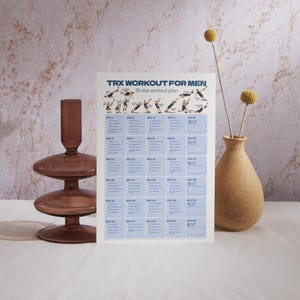 May include: A white rectangular paper sheet featuring a TRX workout plan with the text TRX WORKOUT FOR MEN 30-day workout plan at the top, followed by a grid of daily exercise instructions and illustrations of a person performing various movements.