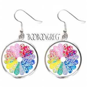 May include: A pair of silver-toned dangle earrings. Each earring features a circular pendant with a colorful floral design in a rainbow of colors. The text "*BOOB&REG*" is above the earrings.