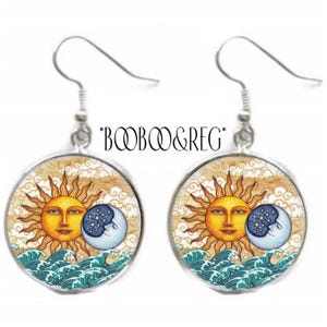 May include: A pair of silver earrings with a celestial design. Each earring features a round pendant with a smiling sun and moon embracing, set against a background of clouds and waves. The text "*BOOB&REG*" is above the earrings.