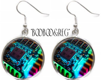 May include: A pair of silver-toned drop earrings featuring circular glass cabochons. The inserts display a vibrant, high-contrast digital circuit board pattern with glowing blue, green, and red hues. The text *BOOBOO&REG* is centered above.