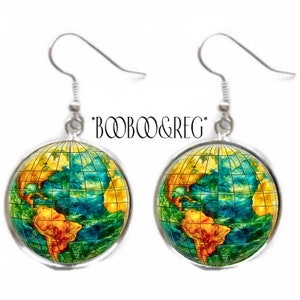 May include: A pair of round dangle earrings featuring a colorful globe map design with yellow landmasses and blue oceans overlaid with a black grid. The earrings have silver-toned metal hooks and the text *BOOBOO&REG* is printed above them.