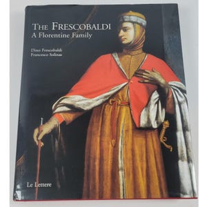 May include: A hardcover book titled The Frescobaldi: A Florentine Family by Dino Frescobaldi and Francesco Solinas. The cover features a portrait of a person in a gold robe, red cape, and head covering, holding a thin staff against a black background.