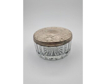 Tarro de polvo de cristal chapado en plata antigua, estilo victoriano, con tapa ornamentada y repujada.