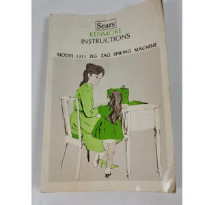 Puede incluir: Un manual de instrucciones blanco para una máquina de coser Sears Kenmore modelo 1311 Zig Zag. La portada presenta una ilustración en tonos verdes de dos figuras en una mesa de costura, con el texto Sears Kenmore Instructions Model 1311 Zig Zag Sewing Machine.
