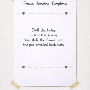 May include: A white rectangular frame hanging template paper with four circular hole markers, dashed alignment lines, and black text that reads: Frame Hanging Template. Drill the holes, insert the screws, then slide the frame onto the pre-installed back slots.