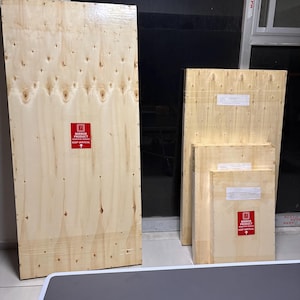 May include: Four rectangular wooden shipping crates of varying sizes, each featuring a light tan wood grain finish. The crates display red warning labels that read MIRROR PRODUCT SENSITIVE FRAGILE KEEP VERTICAL with an upward pointing arrow.