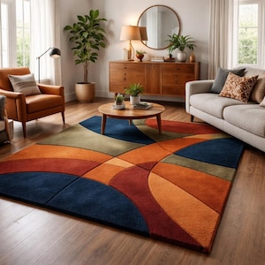 Puede incluir: Una alfombra colorida con un diseño abstracto en tonos de azul, naranja, rojo y verde. La alfombra es rectangular y presenta formas curvas y geométricas. La alfombra está colocada sobre un suelo de madera en un salón.