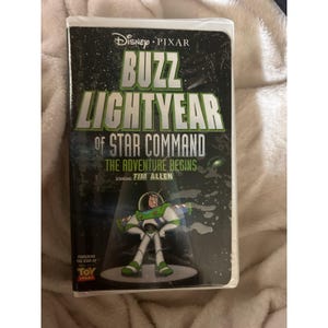 Op de afbeelding: Een VHS-band voor Disney Pixar's "Buzz Lightyear of Star Command: The Adventure Begins" met Tim Allen. De cover toont Buzz Lightyear in zijn ruimtepak. De band komt uit de "Toy Story" franchise.