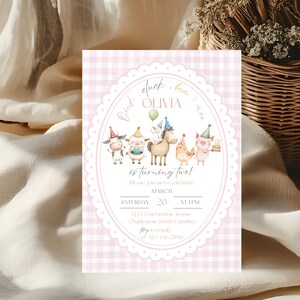 May include: A pink gingham birthday invitation with an oval frame featuring farm animals wearing party hats. The text reads "Olivia is turning two!" and includes date, time, and location details.